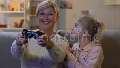 有趣的小女孩把操纵杆从奶奶身边拿走玩电子游戏，上瘾