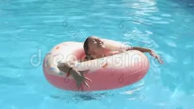 女人正在游<strong>泳池</strong>里玩一个<strong>充气</strong>甜甜圈