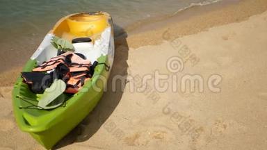 用桨划在沙滩上的皮艇，被蓝色的海水冲刷。 五颜六色的独木舟在波浪状的水晶水中，热带寂寞