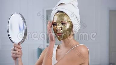 侧面看可爱的女人固定<strong>振兴</strong>化妆品金色组织面具在脸上。