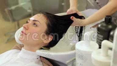 美发师给女孩的头发戴上<strong>保湿</strong>油`<strong>面膜</strong>。