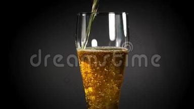 在黑色背景上的玻璃杯里放冷光啤酒。 快来点手工啤酒。 4UHD视频