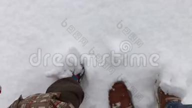 儿童，成年的双脚在冬天的鞋子在雪地里行走