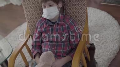 肖像<strong>小生</strong>病的男孩坐在扶手椅上，脸上戴着医疗面具，拿着玩具在家里。 不同的药丸