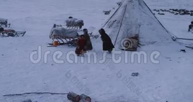三个来自西伯利亚<strong>蒙古包</strong>营的小孩在雪天的雪橇旁玩得很开心
