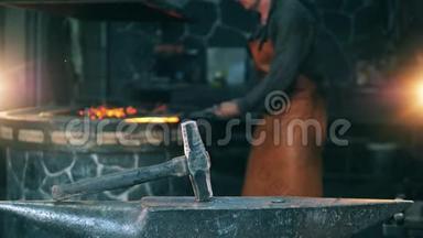 人用锤子打刀子，在锻造厂工作。 铁匠锻造熔融金属