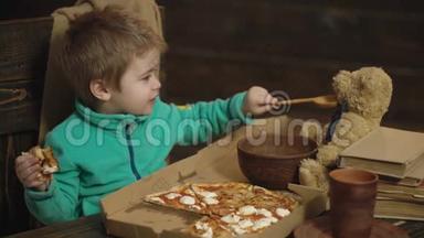男孩拿着一块比萨饼，用木勺喂玩具熊。 男孩和玩具朋友一起享受<strong>午餐时间</strong>。 <strong>午餐时间</strong>
