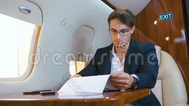 忙碌的商人在私人飞机上飞行时处理文件。 商务舱。