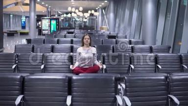 美丽的年轻休闲女子在<strong>空无</strong>一人的机场候机楼做瑜伽冥想