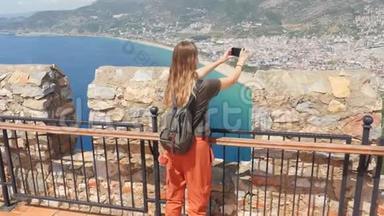 年轻的旅游妇女看着土耳其安塔利亚地区阿拉尼亚半岛的废墟。 著名旅游目的地