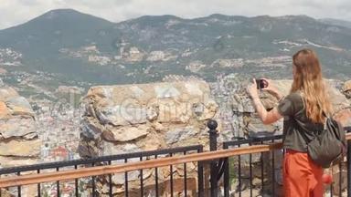年轻的旅游妇女看着土耳其安塔利亚地区阿拉尼亚半岛的废墟。 著名旅游目的地