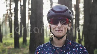 快乐骑自行车女孩拉链在蓝色球衣前，训练前戴黑色头盔和眼镜。 单车概念