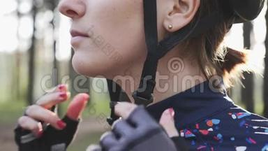 在铁人三项比<strong>赛前</strong>，有注意力的骑自行车的女人戴上头盔和夹子。 铁人三项的概念.. 慢动作