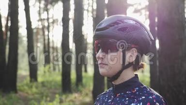 快乐三项运动员女孩戴着黑色头盔戴着自行车眼镜的肖像。 单车概念