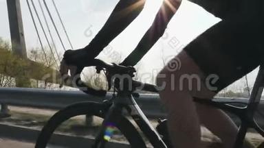 男子骑自行车和换<strong>挡</strong>。 阳光照耀，背景上有桥。 关闭后续射击。 自行车的概念。