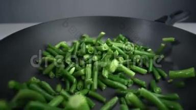 法国菜豆正缓慢地下降到平底锅中，新鲜蔬菜在240fps中下降，烹饪蔬菜混合物