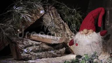 童话般的侏儒戴着圣诞红帽在木屋的背景上闪烁着灯光。 圣诞及新年作文