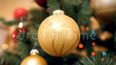 金色圣诞树枝在杉树枝上旋转的4k视频。 五颜六色的灯光闪烁着，闪闪发光