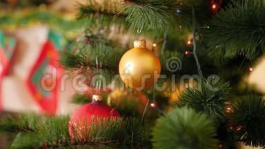 特写4k视频，金色宝珠挂在圣诞树树枝上，闪烁发光的圣诞灯花环上