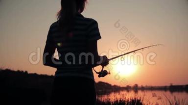 一位年轻女子躺在大自然中，黎明时分在鱼竿上旋转
