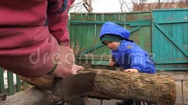 一个手艺精湛的男孩用两个人的横切锯切木头。 一起工作。 子帮助父母.. 强国
