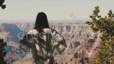后景年轻快乐兴奋的女人站在惊人的沙漠<strong>观察点</strong>，观看不可思议的大峡谷风景。