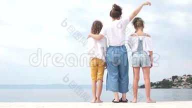 家庭假期快乐，<strong>母亲<strong>节</strong></strong>，穿着牛仔布，蓝色牛仔裤。 <strong>妈妈</strong>和她的两个十几岁的孩子站在岸边