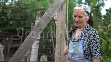 一位老妇人向谷仓打开一扇木门。 第三世界国家，贫穷的农村生活