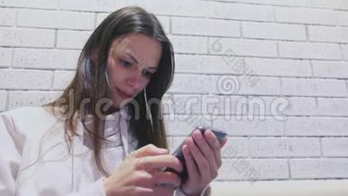 女人正在手机上输入一条信息，坐在咖啡馆里等人。 侧视。