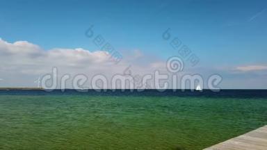 4K视频白色风车站在清澈的绿松石北海。 一艘豪华游艇正慢慢地从他们身边经过。 它在里面