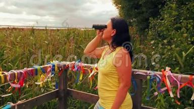 <strong>观景台</strong>上的女游客用望远镜观察风景
