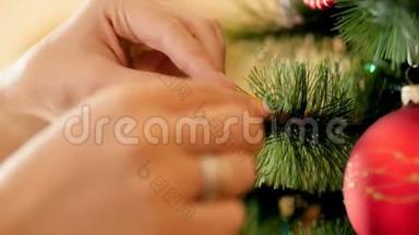 特写4k视频的年轻女子把装饰华丽的星星放在圣诞树树枝上。 <strong>家</strong>庭筹备和<strong>装修</strong>