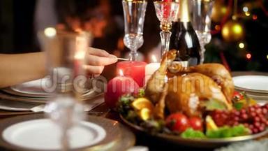 4k视频的妇女点燃蜡烛在桌子上为圣诞节或新年晚餐。 提供丰盛的餐桌