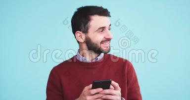 在镜头前，一个快乐而有魅力的男人用他的智能手机在<strong>录音</strong>室里用一个