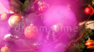 特写4k抽象视频闪闪发光的粉红色花环在装饰圣诞树前。 完美的镜头