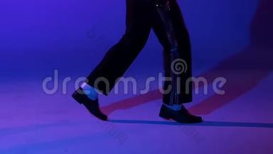 年轻时尚的男子舞蹈风格<strong>迈克</strong>尔杰<strong>克</strong>逊，聚光灯在蓝色背景。 双腿并拢，动作缓慢。