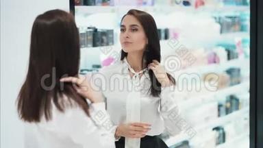 美丽的女孩在<strong>化妆品店</strong>的镜子前打扮自己，慢动作