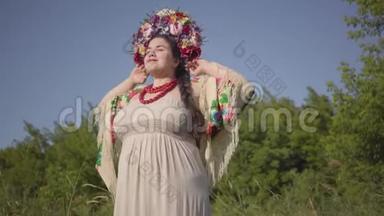 一幅可爱丰满的女人的肖像，头上戴着花环，在绿色的夏日田野上阳光下微笑。 连接