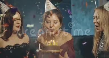 生日女孩在蛋糕上吹蜡烛，和朋友举行家庭聚会。 生日，派对，家庭，友谊，生活方式