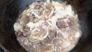 厨师打开锅盖，里面的肉用洋葱在沸水中煎。 圆周率烹饪和搅拌产品