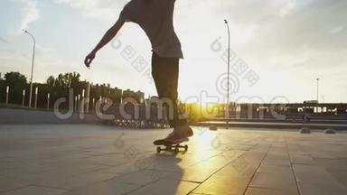 年轻的滑板运动员在日落时滑滑板和跳奥利舞