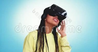 特写非洲女士用虚拟现实环游世界，在工作室的<strong>蓝色背景墙</strong>