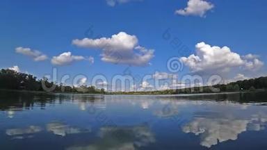 在阳光明媚的夏日，蓝天上的云彩在湖面上流逝。