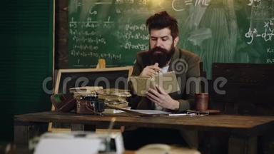 教育毕业与人观念.. 胡子老师在课堂上读一本书。 教室里的老师。 教师和