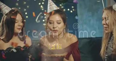 漂亮的生日女孩在蛋糕上吹蜡烛，家庭聚会。 生日，派对，家庭，友谊，生活方式，广告