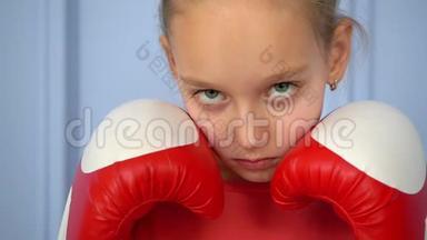 关闭运动的年轻女孩做拳击运动，直接击中。 年轻女孩被隔离在蓝色背景上。 <strong>实力</strong>