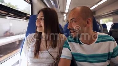 一对优雅的年轻夫妇在<strong>火车车厢</strong>里互相交谈。 快速运输
