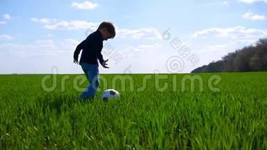 一个快乐的孩子快乐地踢足球，慢悠悠地跑过草地