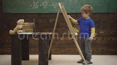 <strong>可爱</strong>的蹒跚学步的男孩在木制背景上画黑板。 小艺术家在木制背景上<strong>画画</strong>。 概念