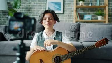 青少年男孩录制视频，在线视频，手持吉他说话手势